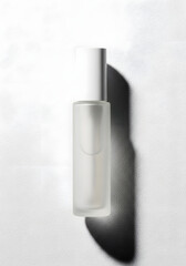 Minimalist frosted glass bottle with white cap casting a long shadow on a white background, ideal for beauty products.