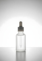 A clear glass bottle with a dropper on a white background.