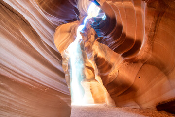 Spectacular Antelope Canyon interior with light beams illuminating red sand and sculpted rock walls