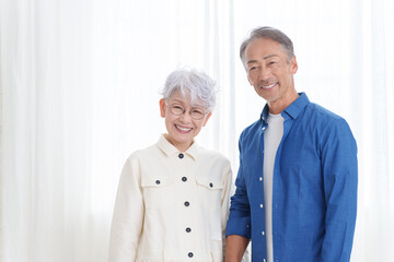 部屋にいる笑顔のシニア夫婦