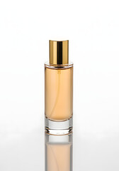 A clear glass bottle of amber-colored perfume with a gold cap, isolated on a white background.