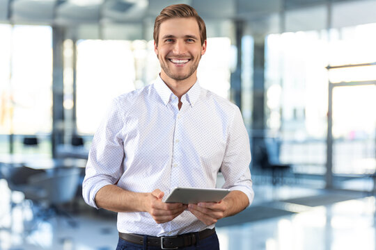 Handsome businessman using his tablet in the office.