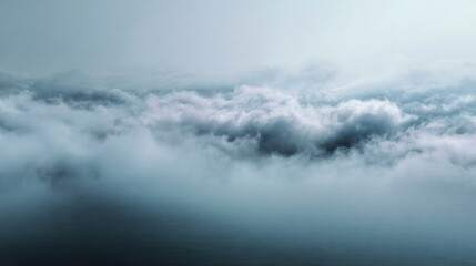 Moody weather creating an atmospheric scene with soft, ethereal clouds covering a calm sea and vast sky