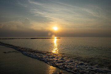 Spokojny zach&oacute;d słońca na plaży nad morzem bałtyckim 