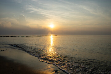 Spokojny zach&oacute;d słońca na plaży nad morzem