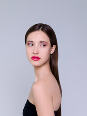 Naklejka premium Beautiful brunette young woman with glowing make-up on blue background Fashion model close-up beauty shot stock photo