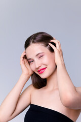 Obraz premium Beautiful brunette young woman with glowing make-up on blue background Fashion model close-up beauty shot stock photo