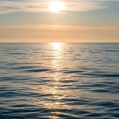 A serene scene of the sun setting over the calm ocean with gentle waves reflecting the warm hues of the sky