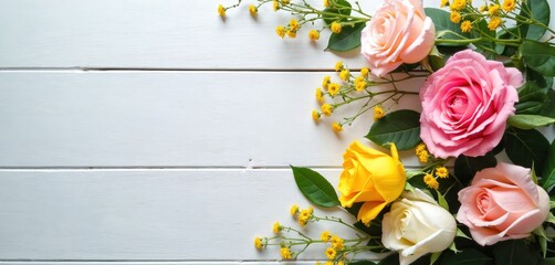 Soft pink yellow and white roses with green leaves and small yellow flowers. Arrange on a light wooden table with copy space on the left. Floral theme perfect for cards invitations or blogs.