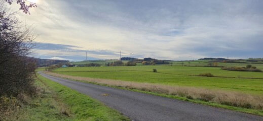 Ländliche Landschaft mit Straße, Feldern und Windkraftanlagen