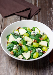 Salad with spinach, blue cheese, pear, grapes, and nuts. Healthy eating. Vegetarian.