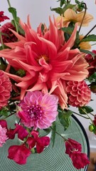 Fototapeta premium Gift modern bouquet of orange and pink flowers, autumn dahlias of various shapes and colors. floristry and gift concept, delivery bouquet