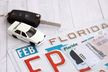 Remote control car keys on Florida license plate with driver license. Concept of driving in...