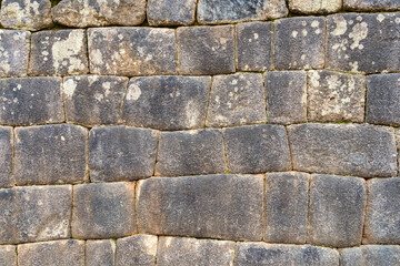 A detailed view of the precisely fitted stones forming an ancient Inca wall at Machu Picchu, Peru.