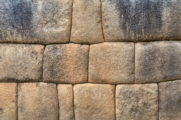 A detailed view of the precisely fitted stones forming an ancient Inca wall at Machu Picchu, Peru.