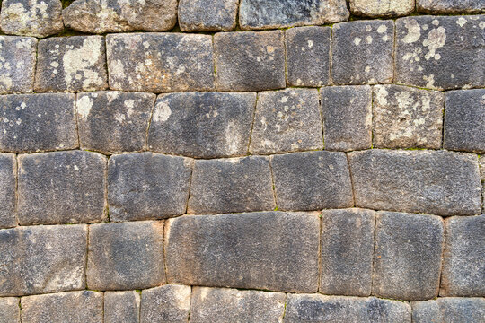 A detailed view of the precisely fitted stones forming an ancient Inca wall at Machu Picchu, Peru.