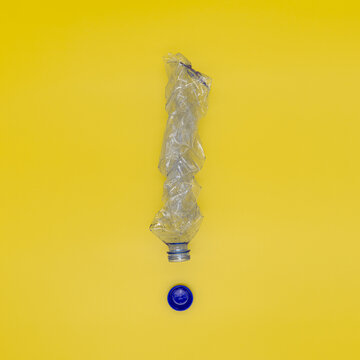Squeezed plastic bottle in the form of an exclamation mark, the concept of preventing the planet from being polluted with garbage and plastic