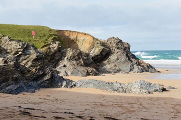 A landscape photo shows a rocky beach on a sunny day in Polly Joke - Cornwall - UK
