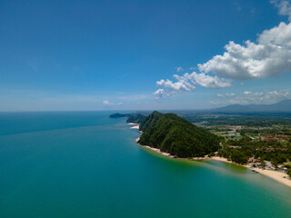 Aerial view of Pantai Bukit Keluang, Besut, Terengganu, showing turquoise waters, coastal cliffs, and clear sunny skies along the scenic shoreline.