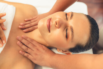 Caucasian woman customer enjoying relaxing anti-stress spa massage and pampering with beauty skin recreation leisure in day light ambient salon spa at luxury resort or hotel. Quiescent