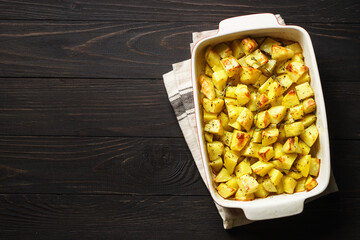 Baked potato with thyme on dark rustic table.