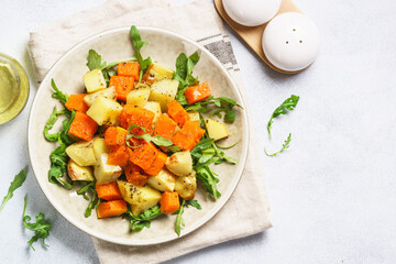 Warm salad with pumpkin, potato and arugula.