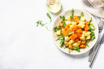 Warm salad with pumpkin, potato and arugula.