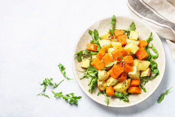 Warm salad with pumpkin, potato and arugula.