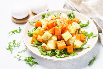 Warm salad with pumpkin, potato and arugula.