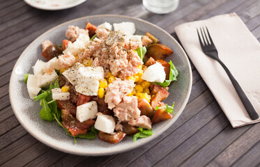 Fish salad with canned tuna and corn, tomatoes and arugula