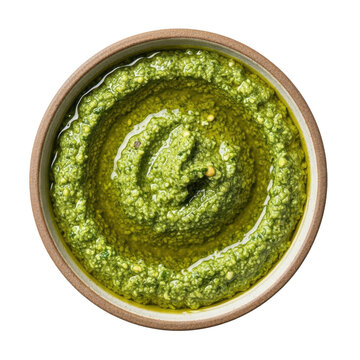 Overhead view of a rustic bowl filled with vibrant green basil pesto drizzled with olive oil against a stark