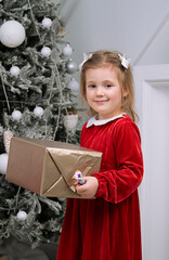 a little girl holds a Christmas gift box
