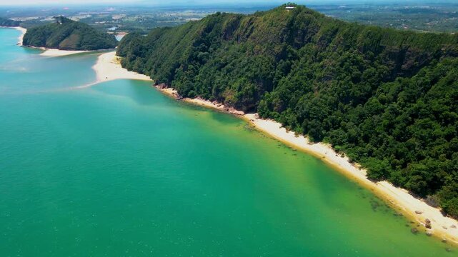Aerial view of Pantai Bukit Keluang, Besut, Terengganu, showing turquoise waters, coastal cliffs, and clear sunny skies along the scenic shoreline.