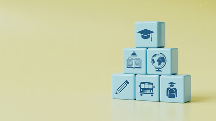 Stack of light blue cubes with education icons like graduation cap, globe, and school bus
