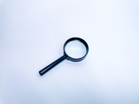 Top view of classic black magnifying glass on white background for analysis and research