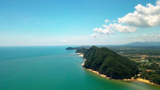Aerial view of Pantai Bukit Keluang, Besut, Terengganu, showing turquoise waters, coastal cliffs, and clear sunny skies along the scenic shoreline.