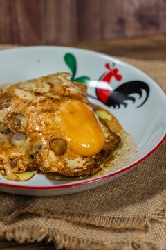 Fried Egg Delight: A close-up shot of a perfectly fried egg with a rich, golden yolk served in a rustic bowl adorned with a traditional rooster motif. The dish is presented on a burlap cloth.