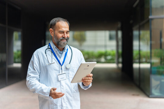Mature doctor using digital tablet for modern healthcare