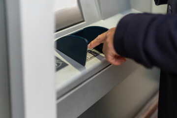 Person entering pin on atm keypad for secure transaction