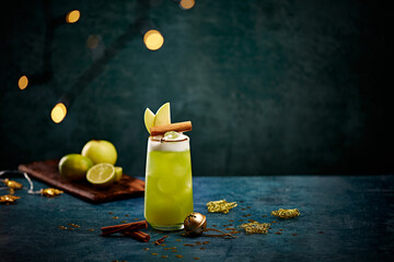 Festive Green Holiday Cocktail with Apple and Cinnamon Garnish