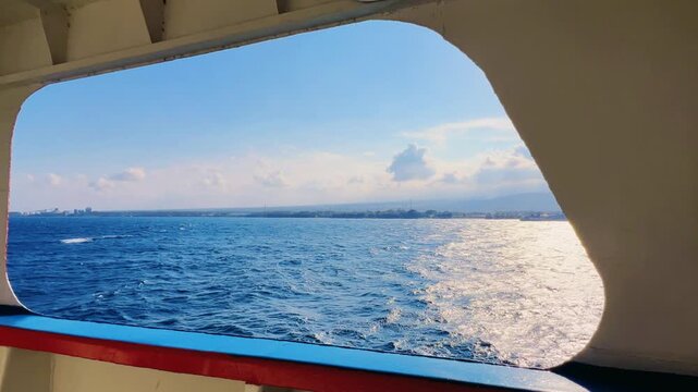 Bali, Indonesia - August 27, 2025: Car and passenger ferries cross the Bali Strait from Gilimanuk Harbor to Ketapang Harbor on the island of Java. View of the strait from the ferry deck. 4K