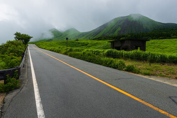 Lush green hillsides around Mt. Aso close to Nakadake Crater with views on the cone of Komezuka crater and other peaks, Kumamoto, Japan