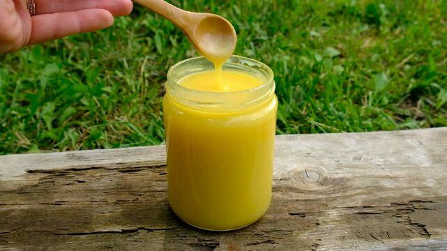 Ghee in a jar in a meadow. Selective focus.