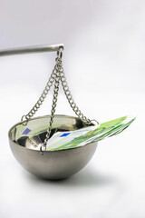 100 Euro banknotes on balance scale symbolizing financial justice concept.