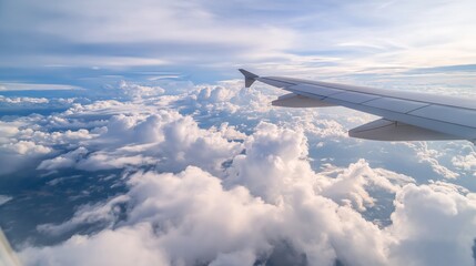 Aerial view from airplane window with bright white clouds and blue sky, travel concept