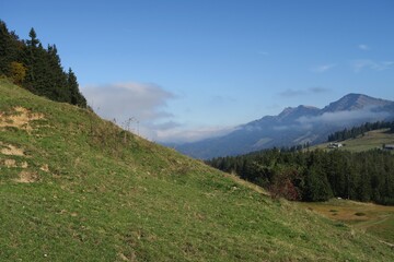 Vom Wanderweg auf dem Kojen-Schichtkamm in Riefensberg fällt der Blick auf die Hochgratkette im Hintergrund der Allgäuer Alpen. Vor den Hochgratbergen ist Herbstnebel zu sehen.