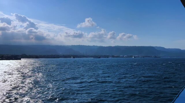 Bali, Indonesia - August 27, 2025: Car and passenger ferries cross the Bali Strait from Gilimanuk Harbor to Ketapang Harbor on the island of Java. View of the strait from the ferry deck. 4K