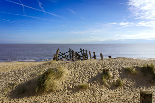 Weathered Groynes and Sandy Dunes &mdash; Coastal Decay, Contrails, and Shoreline Stillness in Great Yarmouth