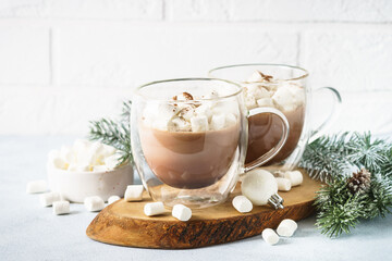 Christmas hot chocolate or cocoa with marshmallow on white with christmas decorations.
