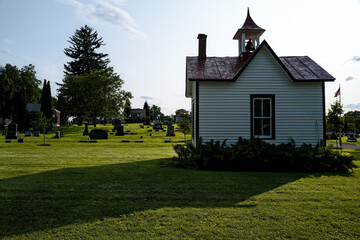 Small Historic Cemetery Office with Red Roof beside Gravestones at Afternoonsunset